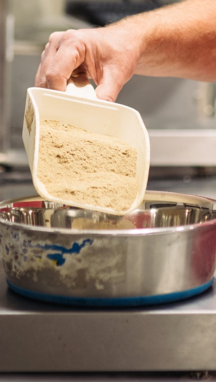 עובד של חברת הילס מודד מרכיבים על מאזנים