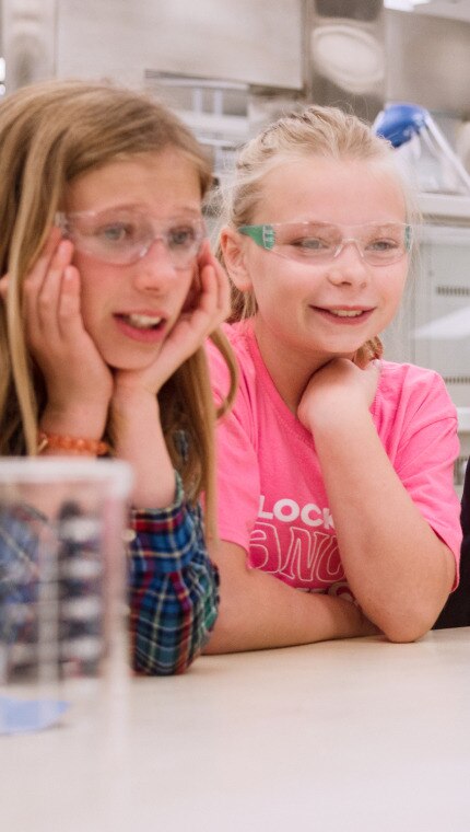 מדען של הילס מראה לקבוצת ילדים ציוד מעבדה 